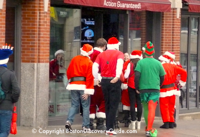 Santa Speedo runners going into Games On sports bar near Boston ' s Fenway Park