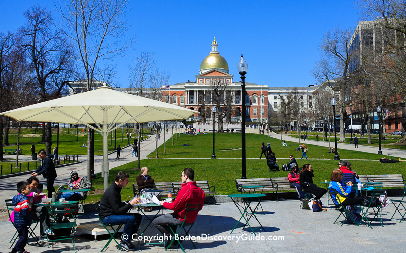 Tables and park benches on Boston Common in front of the Massachusetts State House