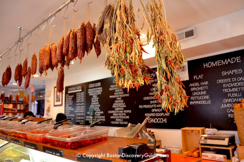 Sausages and chilis hanging over the meat counter n Bricco Salumeria in Boston's North End Sausages and chilis hanging over the meat counter n Bricco Salumeria in Boston's North End