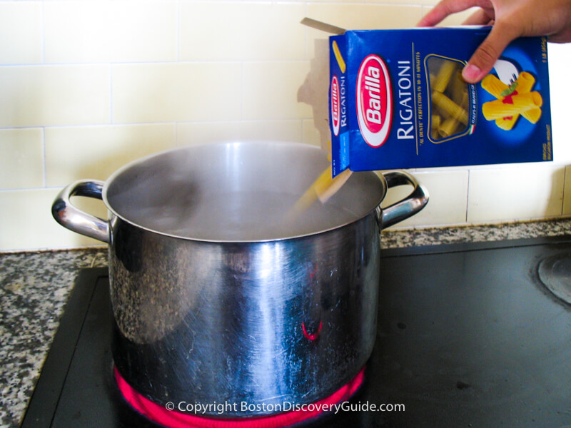 Pouring the pasta into the pot Pouring the pasta into the pot