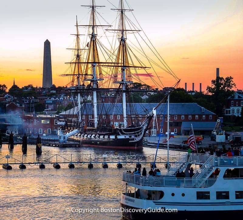 USS Constitution at dusk, with Bunker Hill Monument in the background 