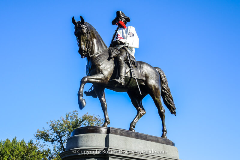 George Washington is wearing a Red Sox shirt and fake red beard in honor of the beards <br>
  all the Red Sox players grew during the months before their recent World Series Championship