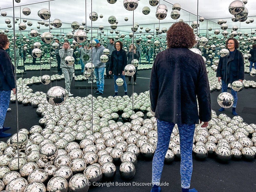 Mirrored walls and silver balls inside Yayoi Kusama's Lets Survive Together infinity room