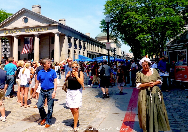 Costumed tour guide next to the red stripe of the Freedom Trail in Faneuil Marketplace