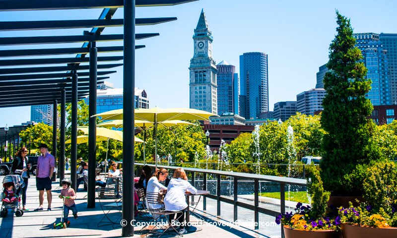 Relaxing on Boston's Rose Kennedy Greenway, with the historic Custom House and Financial District skyscrapers in the background