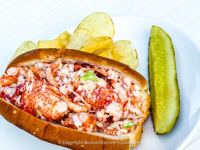 Lobster roll served with potato chips and a pickle