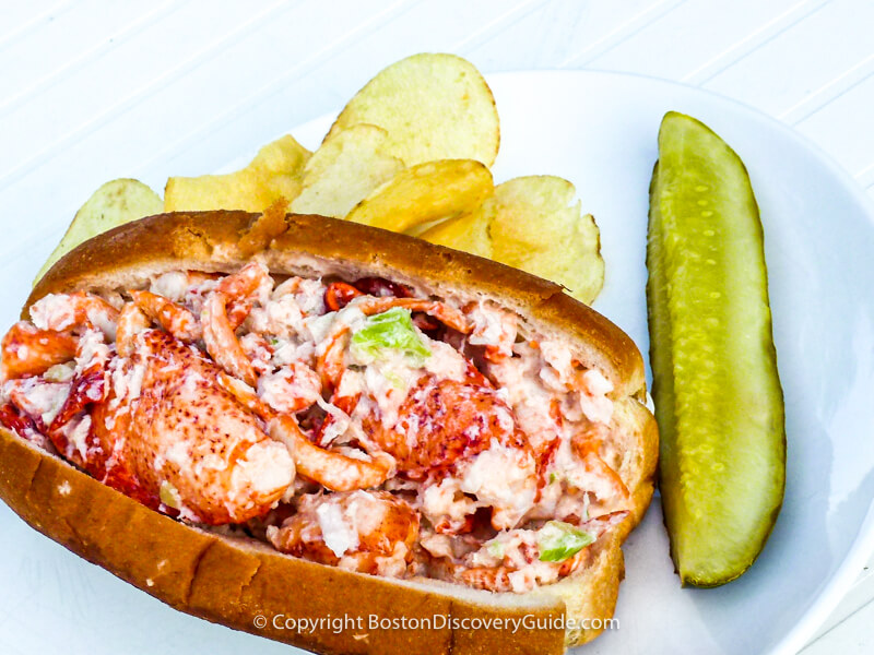 Lobster roll served with potato chips and a pickle Lobster roll served with potato chips and a pickle