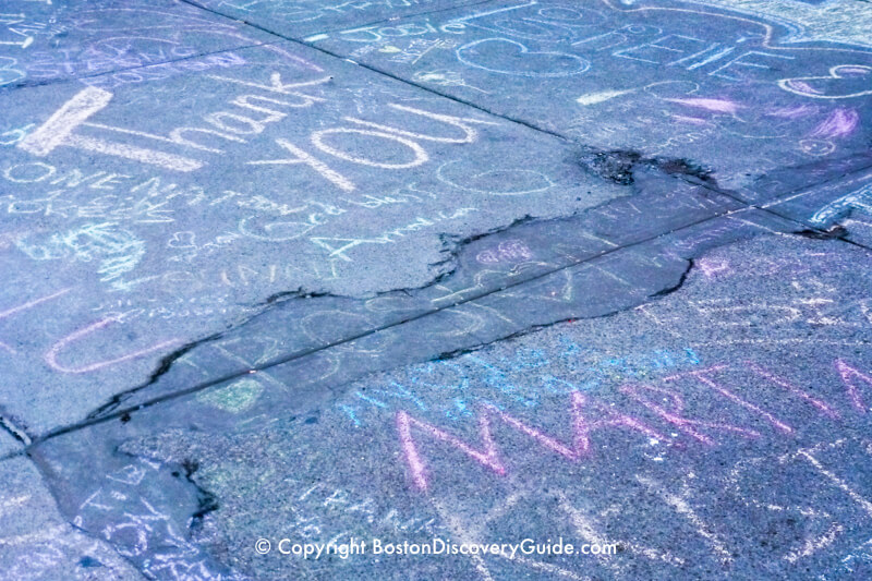 Tributes written in chalk on the sidewalk along Newbury Street