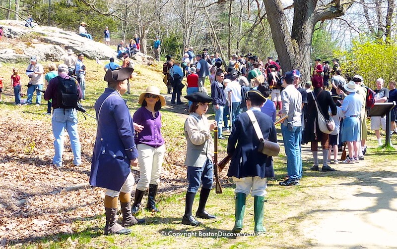 Colonial Reenactors mingle with spectators during a reenactment of a battle with the British as they fled back to Boston Colonial Reenactors mingle with spectators during a reenactment of a battle with the British as they fled back to Boston