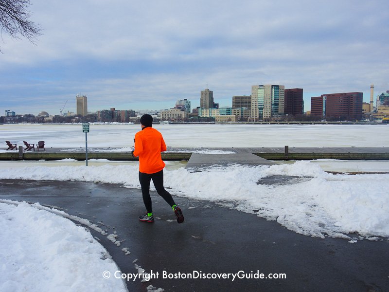 Winter walking tour of Boston: Jogger along the Esplanade, next to the frozen Charles River Winter walking tour of Boston: Jogger along the Esplanade, next to the frozen Charles River