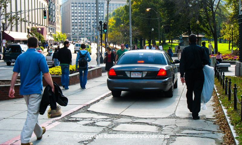 Car stopped (illegally) on the sidewalk along Tremont Street by Boston Common, next to the red stripe marking the Freedom Trail